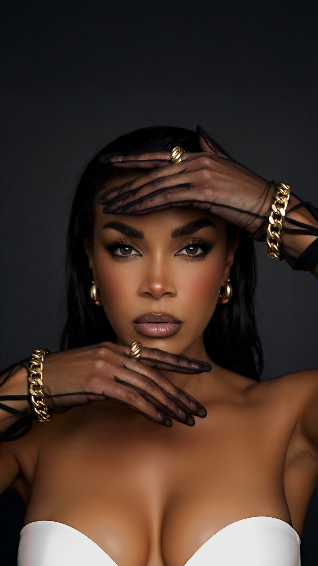 NiCalé photographed in sheer black gloves, stacked gold chains and a white bustier
